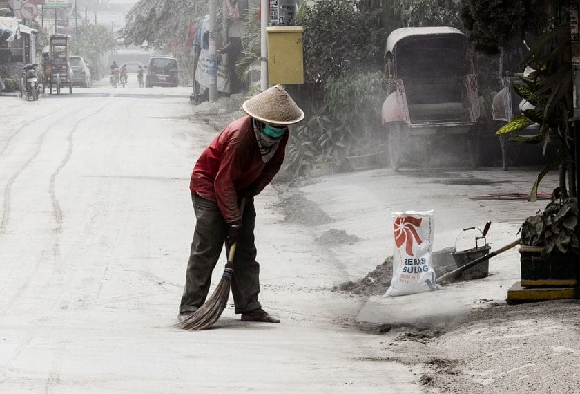 A man sweeping up ash volcanic ash in Yogyakarta; Indonesaia, during the 2014 eruption of Kelud.